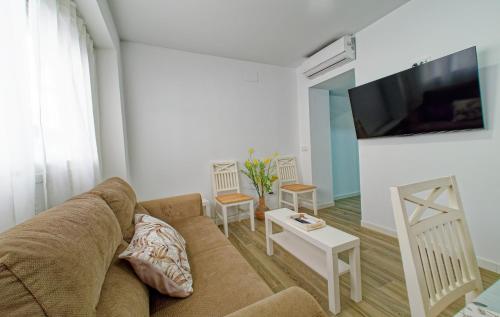 a living room with a couch and a flat screen tv at Junto Playa de Levante, céntrico, Smart Tv 55- by Aloha Palma in Águilas