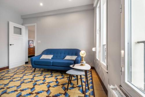 um sofá azul numa sala de estar com uma mesa em MyHouseSpain - Céntrico y luminoso piso em Gijón