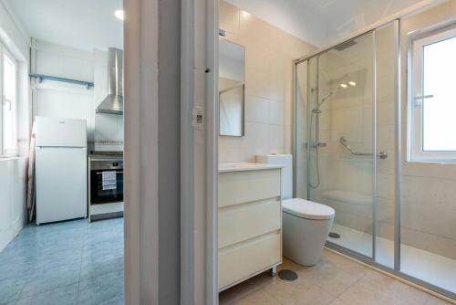 uma casa de banho com um chuveiro, um WC e um frigorífico em MyHouseSpain - Céntrico y luminoso piso em Gijón