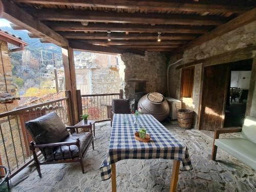 a patio with a table and chairs on a balcony at PITHARIA in Askas