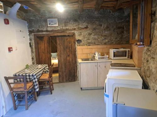 a small kitchen with a table and a microwave at PITHARIA in Askas