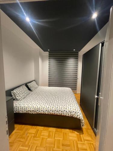 um quarto com uma cama com um tecto preto em Sonny’s Penthouse em Gnjilane