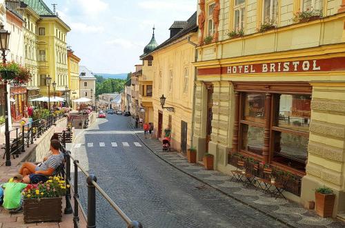ulica w mieście, na której ludzie siedzą na krawędzi w obiekcie Apartmán č.2 w Bańskiej Szczawnicy