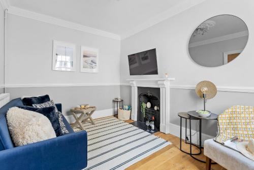uma sala de estar com um sofá azul e uma lareira em Higher Cottage with Parking em Dartmouth