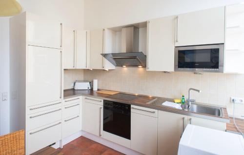 a white kitchen with white cabinets and a sink at City Villa - perfect for bigger groups in Goch