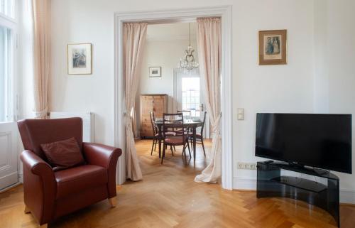 a living room with a television and a chair and a table at City Villa - perfect for bigger groups in Goch
