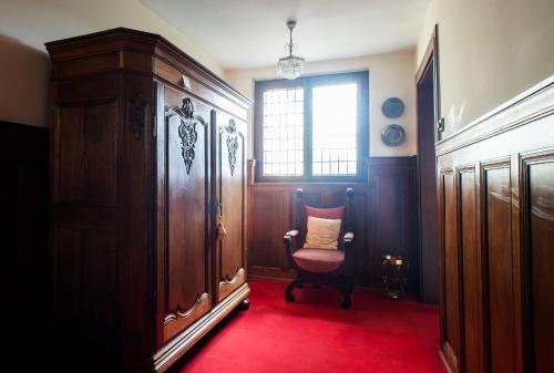 een kamer met een stoel, een raam en een rode loper bij City Villa - perfect for bigger groups in Goch