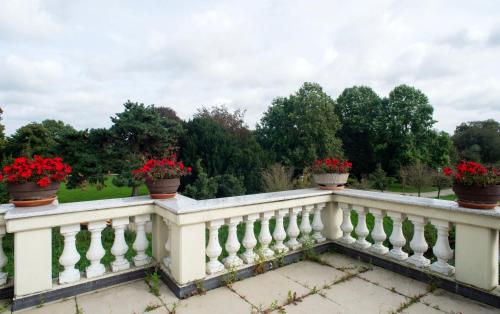a white railing with red flowers on it at City Villa - perfect for bigger groups in Goch