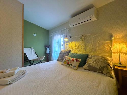 1 dormitorio con 1 cama blanca grande con almohadas en Casa Rural de La Vega, en El Campo