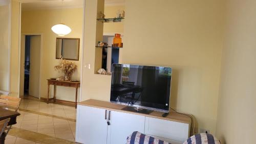 a flat screen tv sitting on top of a white cabinet at Appartamento Stella Marina a due passi dal mare e dal centro in Marina di Carrara