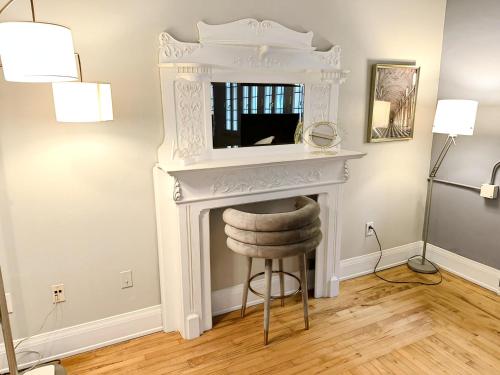 a fireplace with a mirror above it with a stool at The Historic Lyric Penthouse with Private Rooftop in Cincinnati