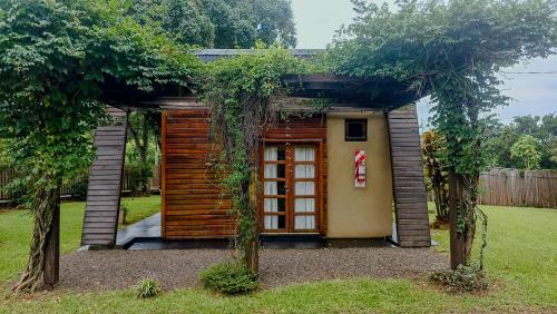 a small house with a door in a yard at Yvyra Lodge in San Ignacio