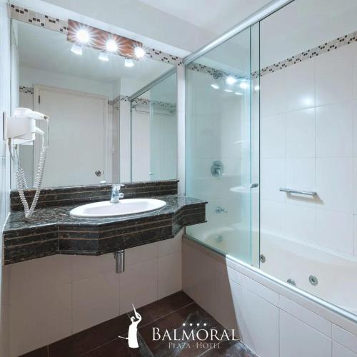 een badkamer met een wastafel en een glazen douche bij BALMORAL Triple SUITES in Montevideo