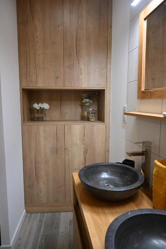 un bagno con un grande lavandino nero su un bancone in legno di L’escale enchantée a Bouzigues