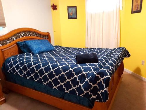 a bedroom with a bed with a blue and white comforter at Lovely comfy home private bath in central Calgary in Calgary