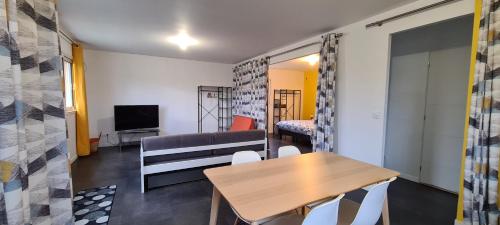 ein Wohnzimmer mit einem Tisch und einem Sofa in der Unterkunft loft près futuroscope in Montamisé