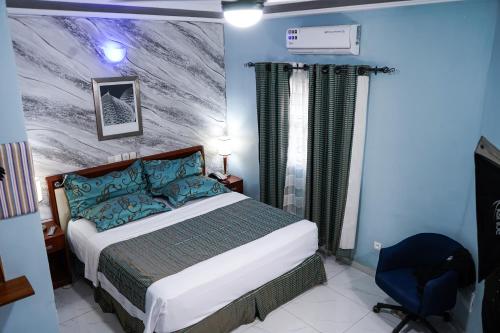 1 dormitorio con 1 cama y un mural en la pared en EKA ELITE HOTEL en Lomé