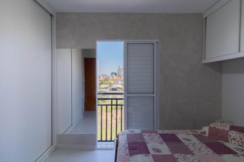 a bedroom with a bed and a view of a city at Cobertura 2 quartos Tucuruvi in Sao Paulo