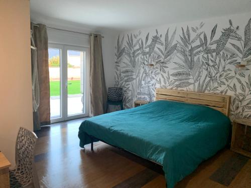 une chambre avec un lit avec une couette verte dans l'établissement L'étape de Marcel - Zanini, à Avoine