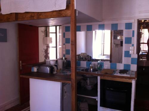 - une cuisine avec du carrelage bleu et blanc sur le mur dans l'établissement LES PETITS STUDIOS/MEZZANINE du PANIER, à Marseille