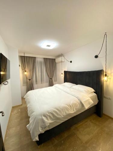 1 dormitorio con 1 cama grande con sábanas blancas en Boutique Apartment DOLCHE VITA, en Smolyan
