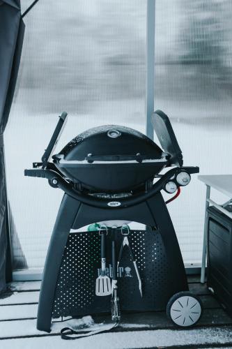 a black grill sitting on top of a floor at Wolf Cottage in Pabaži