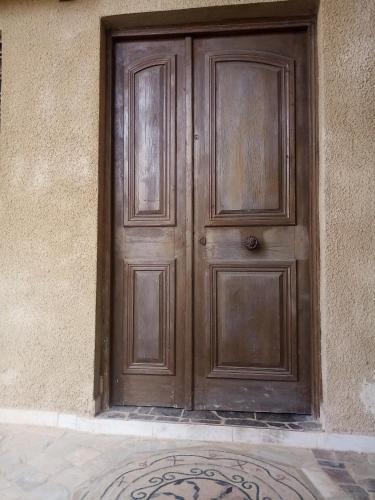 uma porta de madeira na lateral de um edifício em Appartement a 15km airport tunis em Raoued