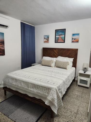 ファハルドにあるBeautiful Caribbean Waters - 7 Seas Beach, El Yunque, Icacos Islandのベッドルーム1室(大型ベッド1台、木製ヘッドボード付)