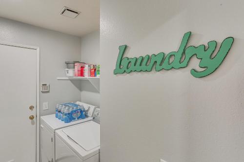 a bathroom with a laundry sign on the wall at Victorville Home with Fenced Backyard and Patio! in Victorville