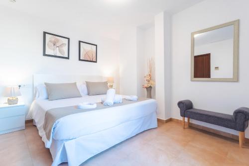 a white bedroom with a large bed and a mirror at Borne Suites TI by MallorcaSuites in Palma de Mallorca