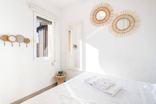 ein weißes Schlafzimmer mit einem Bett und zwei Spiegeln in der Unterkunft Coblanca 5-15-4 Apartment Levante Beach in Benidorm