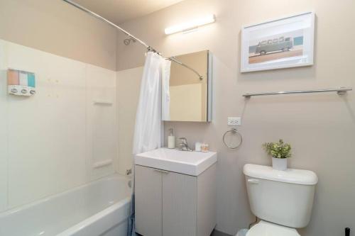 a bathroom with a sink and a toilet and a bath tub at McCormick 2br/2ba KING beds suite with gym and optional parking for up to 6 guests in Chicago