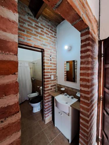 Baño de ladrillo con lavabo y aseo en Kurpachana cómodos departamentos a 3 cuadras de la plaza. en Tilcara