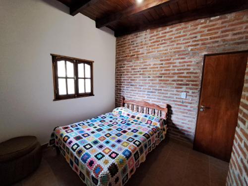 蒂爾卡拉的住宿－Kurpachana cómodos departamentos a 3 cuadras de la plaza.，一间卧室设有一张床和砖墙