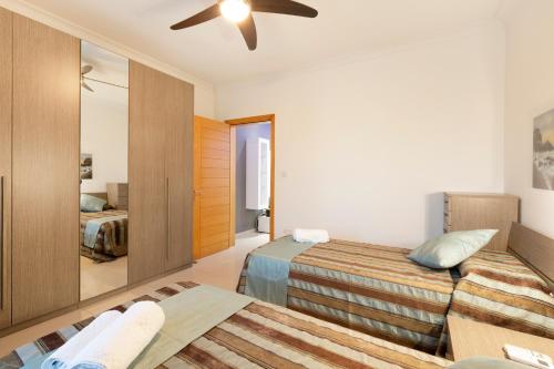 een slaapkamer met 2 bedden en een plafondventilator bij Sliema Bluemist near Balluta Bay in Sliema