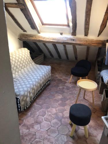 une chambre mansardée avec un canapé, deux chaises et une table dans l'établissement STUDIO sous les toits de PARIS GRANDS BOULEVARDS, à Paris