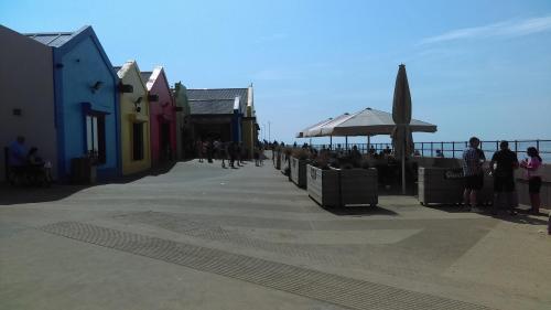 a group of people walking on a sidewalk near the ocean at THE OLD LAUNDRY, Prestatyn, North Wales - a unique little dog-friendly space, a 5 min walk to beach & town! in Prestatyn