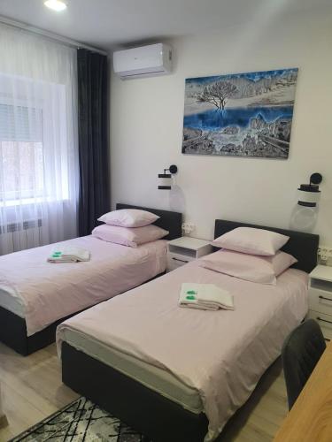 a bedroom with two beds and a painting on the wall at Comfort Stay, EV, Parking in Bolesławiec
