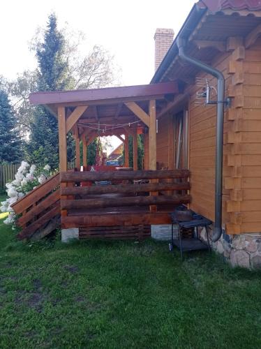 a wooden pergola on the side of a house at U Czesiuka in Jałowo