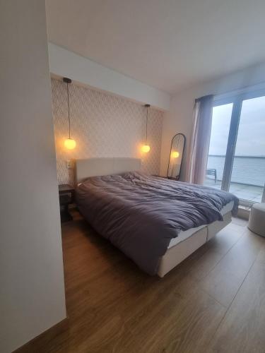 a bedroom with a large bed and a large window at Beautiful Bruges in Zeebrugge