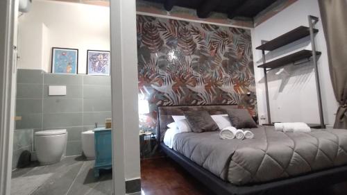 Plebiscito Suite Apartment في نابولي: غرفة نوم عليها سرير وفوط
