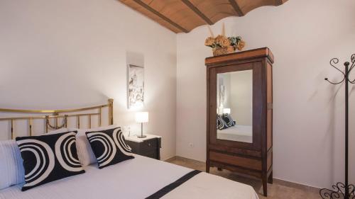 sypialnia z łóżkiem i dużym lustrem w obiekcie Apartamentos Florinda de la Cava Toledo - 1 w mieście Toledo