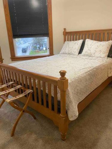 a bedroom with a wooden bed and a window at Small Town Hideaway in Wyalusing