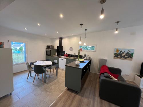 une cuisine et un salon avec une table et des chaises dans l'établissement L' Abri du Saule, à Aussillon