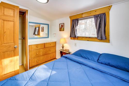 Un dormitorio con una cama azul y una ventana en Pet-Friendly Irons Cottage about 4 Mi to Sand Lake!, en Irons