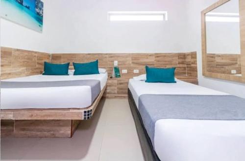 2 camas en una habitación con almohadas azules en HOTEL CASA GIRARDOT en Medellín
