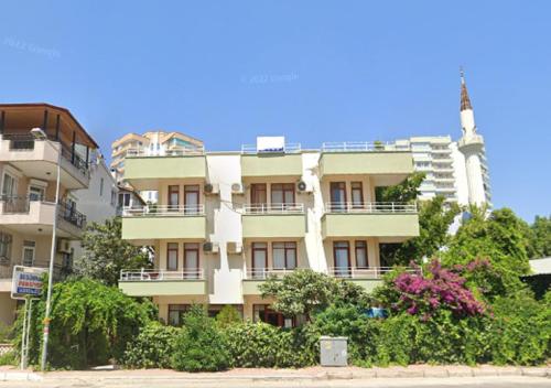 un edificio de apartamentos con una torre en el fondo en Begumhan Pansiyon, en Antalya
