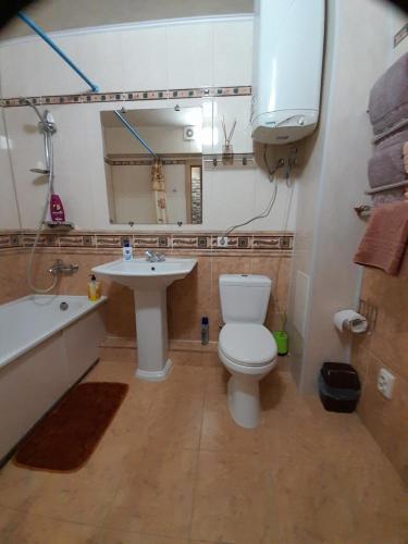 ein Badezimmer mit einem WC, einem Waschbecken und einem Spiegel in der Unterkunft Apartment in a New House in Krementschuk