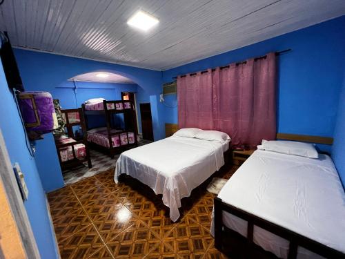 Duas camas num quarto com paredes azuis em Nature Iguazu hostel B&B em Puerto Iguazú
