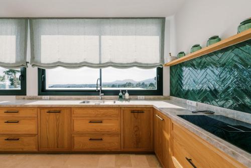 a kitchen with a sink and a large window at Can Pep Gibert in Ibiza Town